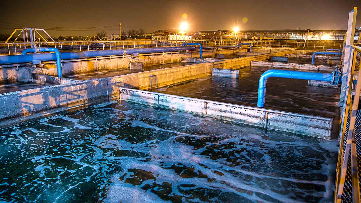 Modern wastewater treatment plant of chemical factory at night. Water purification tanks